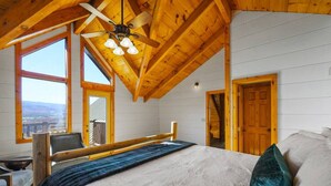 A bedroom with a bed, a desk, and a chair. There are windows and a door. - 5 Decks | Hot Tub | Views | Fire Pit | Pool Table (Sevierville)