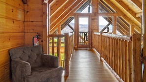 A wooden interior with a sofa, a staircase, and a view of the outdoors. - 5 Decks | Hot Tub | Views | Fire Pit | Pool Table (Sevierville)