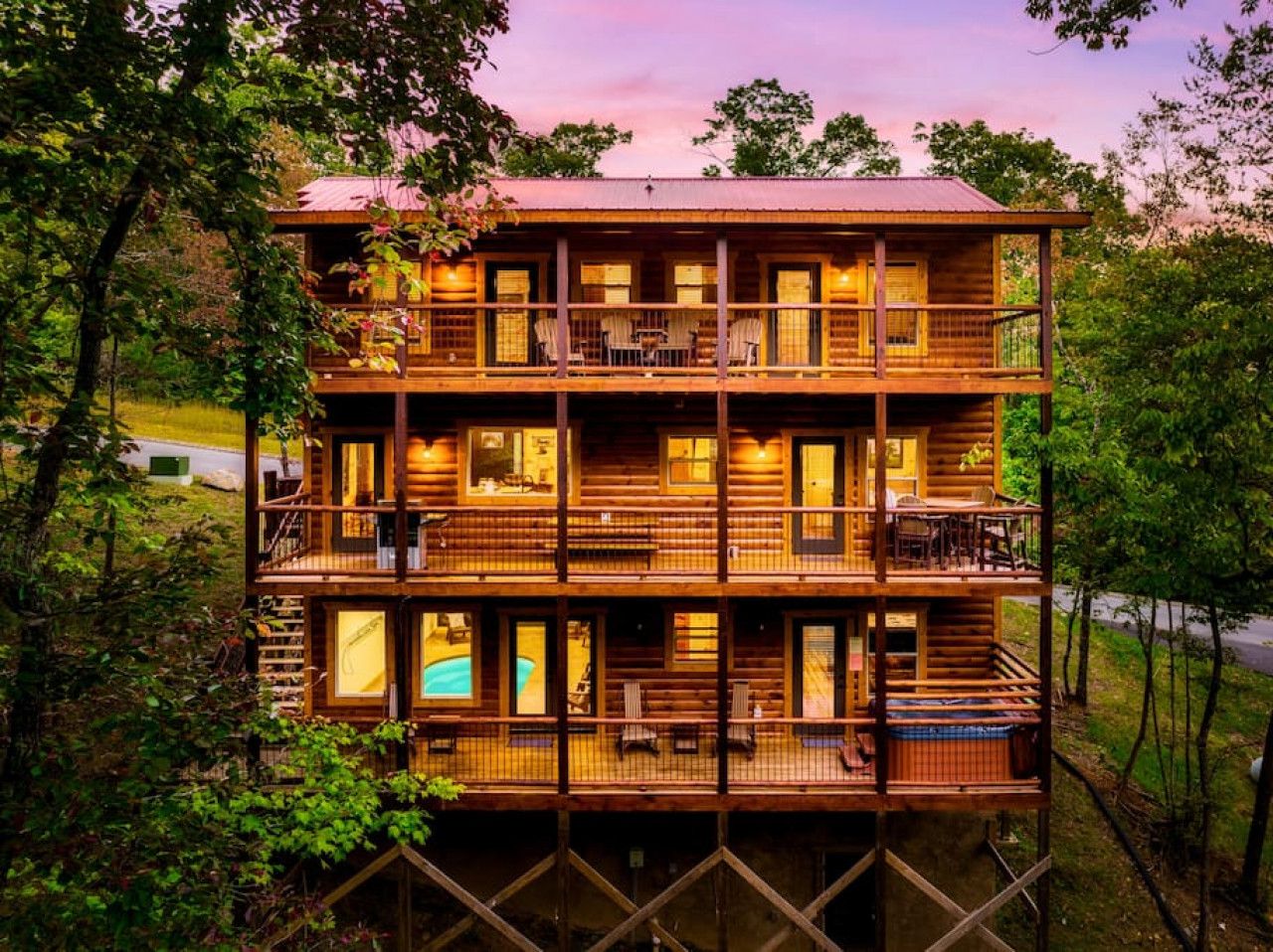 A multi-level wooden cabin with balconies, outdoor seating, and a swimming pool.