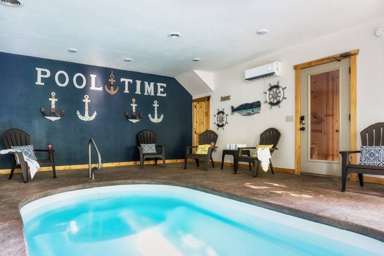 A pool area with a sign reading "POOL TIME" and several Adirondack chairs around the pool.
