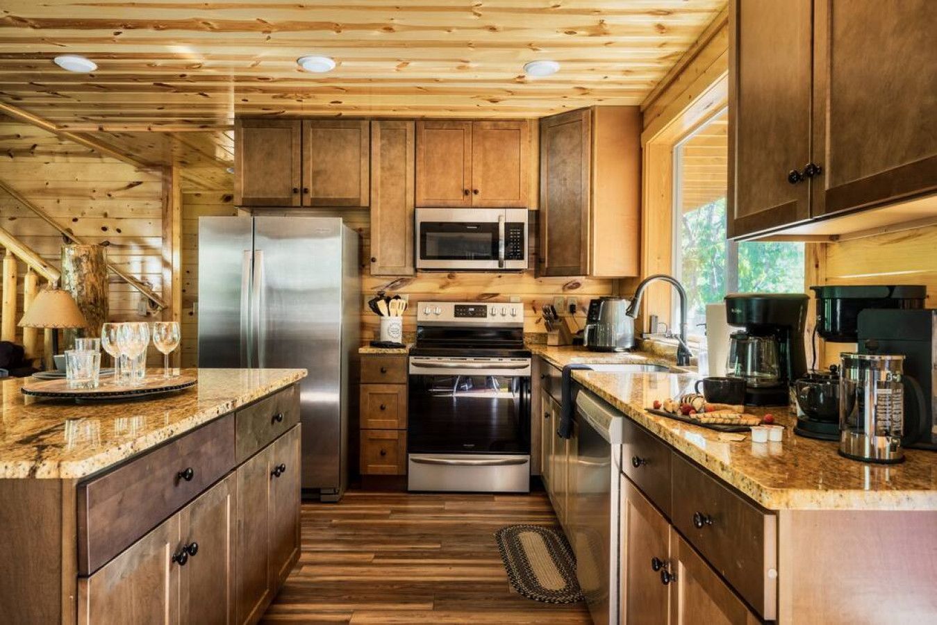A compact kitchen with wooden cabinets, stainless steel appliances, and a granite countertop.