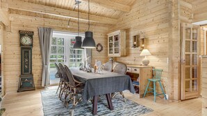 Un intérieur en bois comprenant une table à manger, des chaises, une horloge et un buffet.