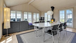 Una habitación amplia con un gran comedor, un sofá y una chimenea.
