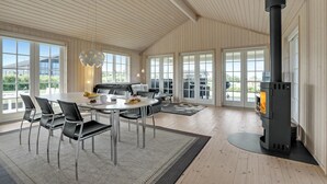 Una habitación amplia con una gran mesa de comedor, sillas, un sofá y una chimenea.