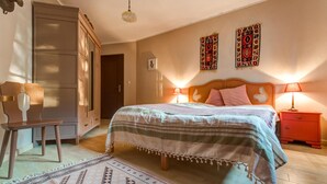 A bedroom with a bed, a nightstand, a chair, a wardrobe, and two wall hangings. - Awesome home in Wygon with WiFi (Wygon)