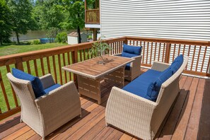A deck with wicker furniture and a table, overlooking a lake. - Luxe Waterfront Retreat w/ Infrared Sauna & Red Light. Near New Paltz (wallkill)