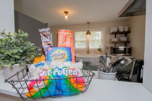 A kitchen counter with a basket containing various packaged food items.