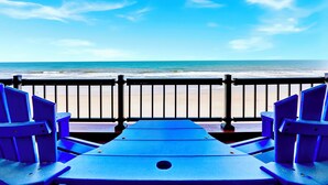 Un área de estar junto a la playa con vista al océano.