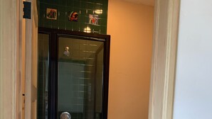 Une salle de bain avec une douche à parois de verre, des toilettes et un porte-serviettes.