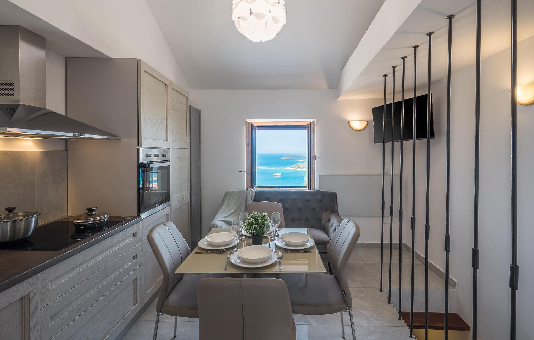 Een moderne keuken met een ingebouwde oven en een eetgedeelte met uitzicht op zee.