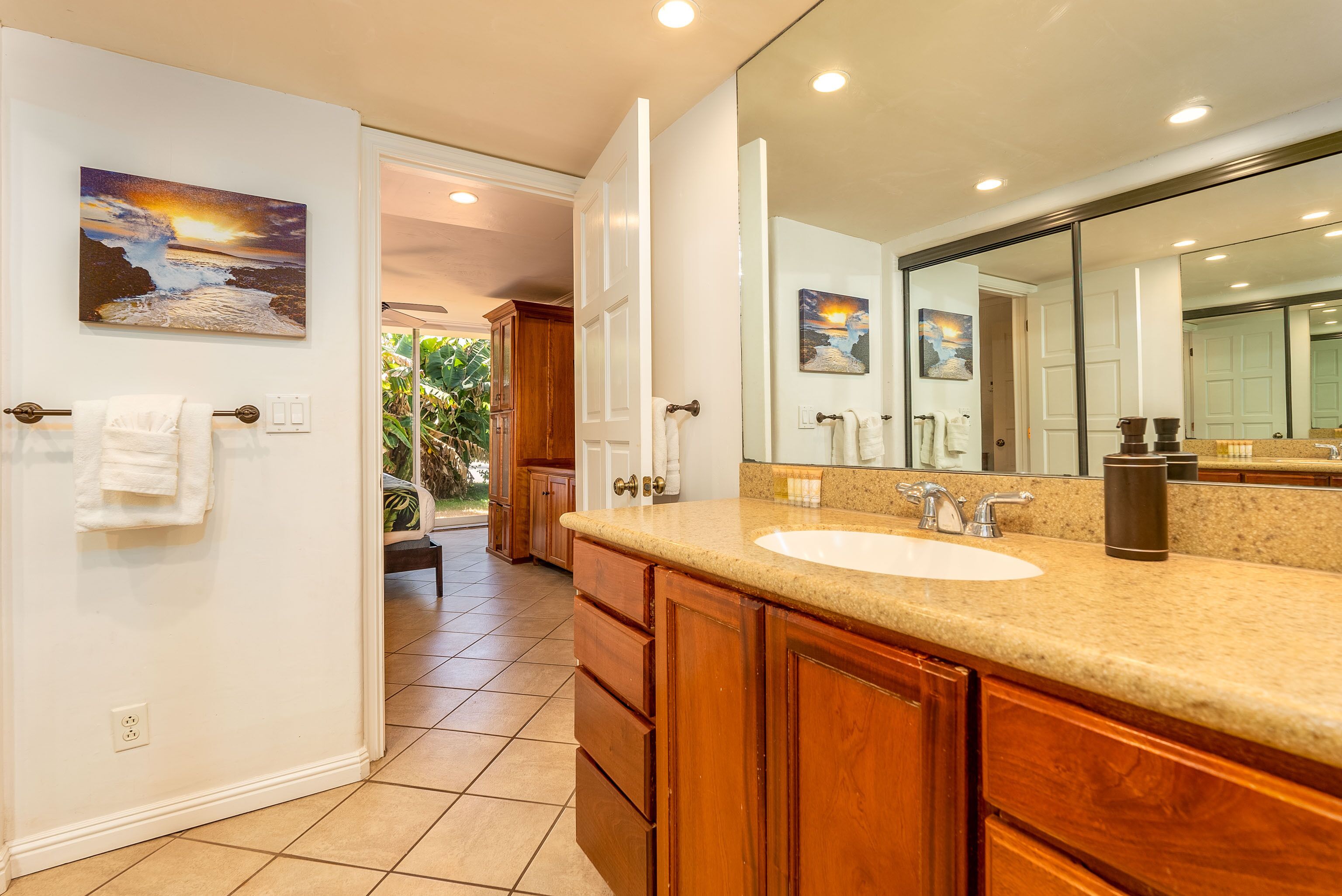 A bathroom with a large sink, wooden cabinets, and a mirror.