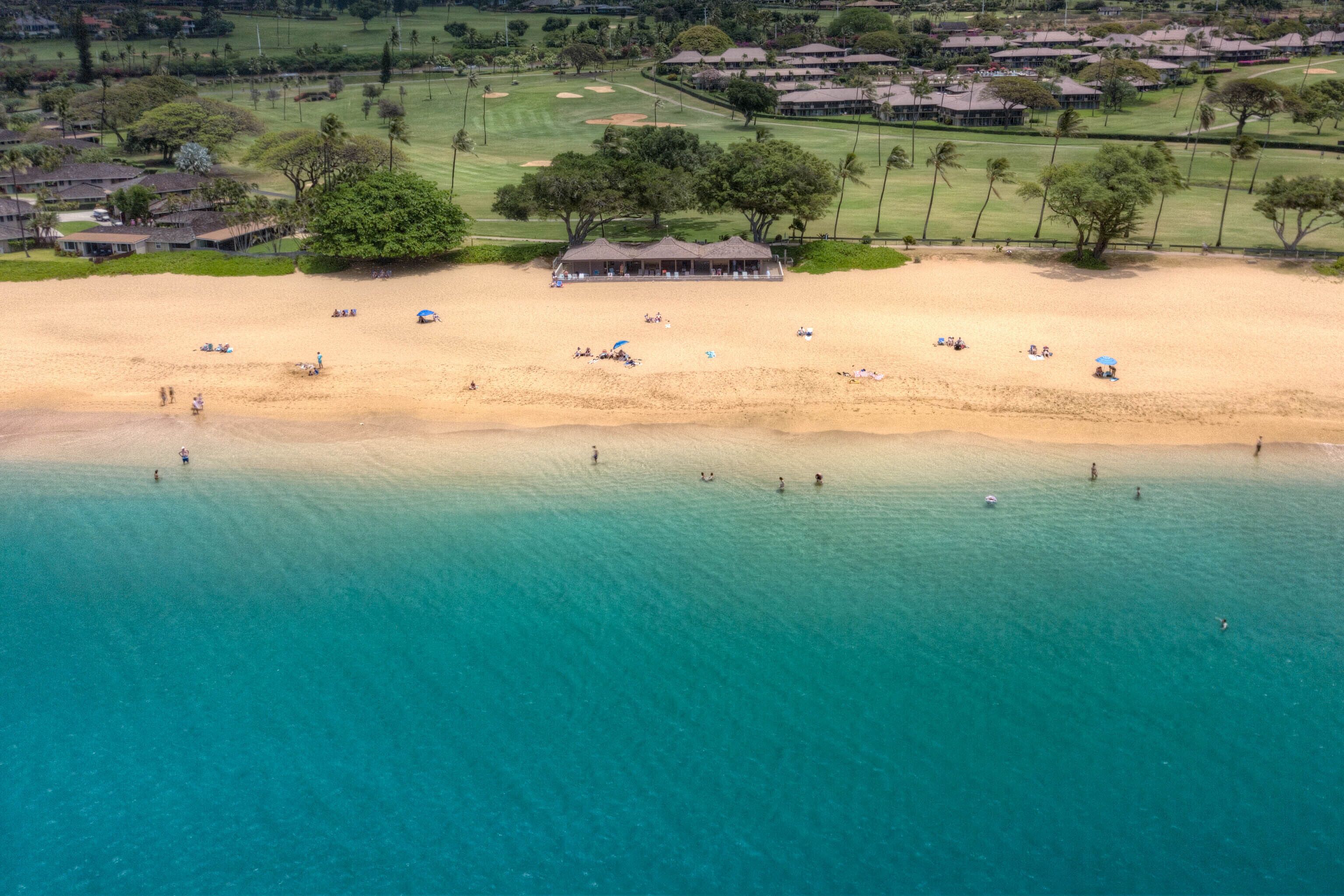 An aerial view of a beach with a building in the background.