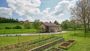 Une maison de campagne avec un jardin et des potagers.
