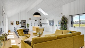 Een moderne woonkamer met een bank, stoelen en een eethoek.
