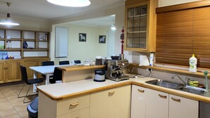 A kitchen with wooden cabinets, a coffee machine, and a sink. - Hawker 4BR House（Air-Con, WiFi, Netflix, Parking） (Hawker)