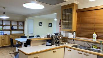 A kitchen with wooden cabinets, a coffee machine, and a sink.