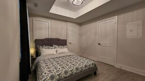 Un dormitorio con una cama grande, una lámpara en el techo y un armario.