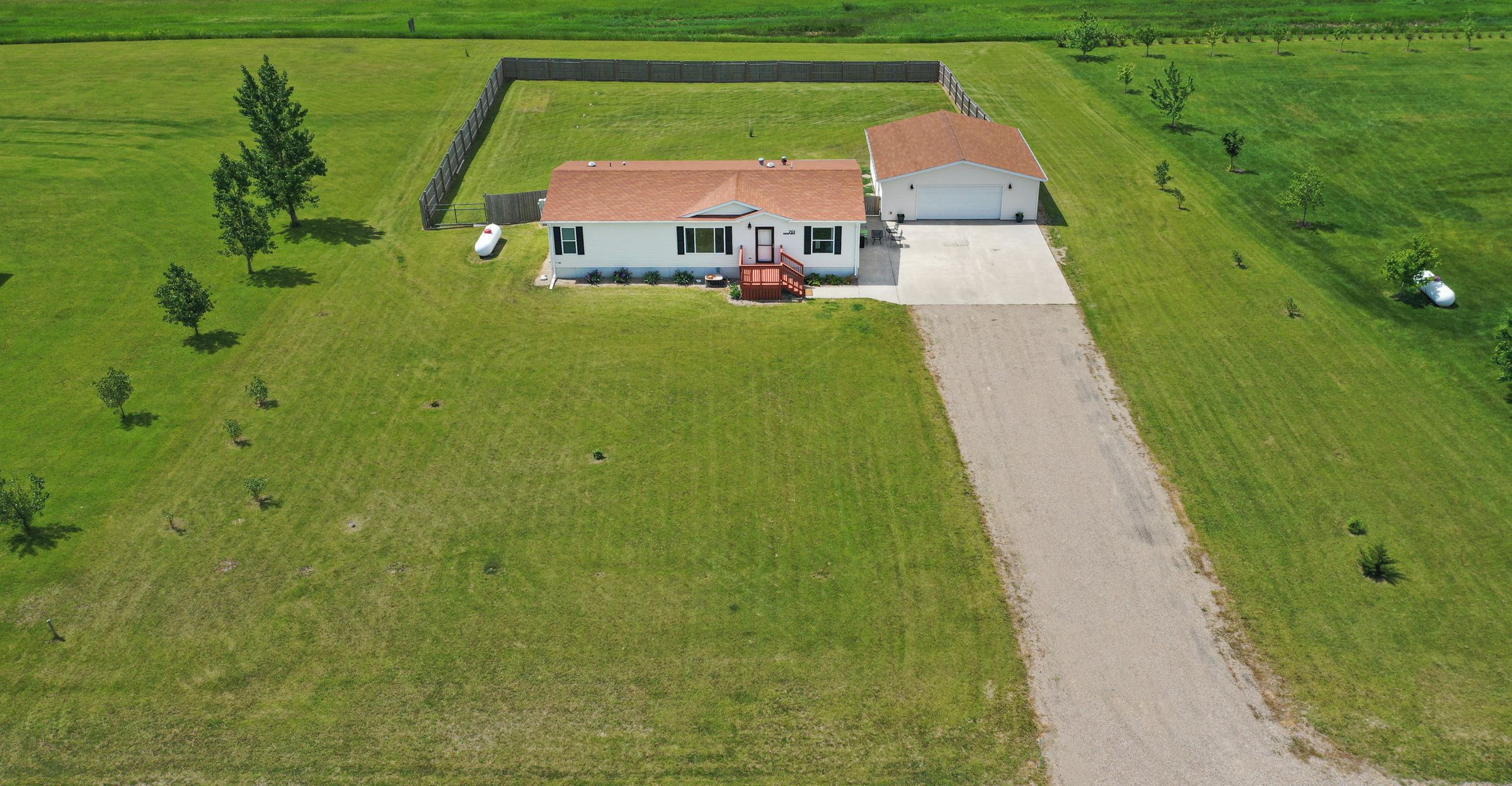 Vue aérienne d'une propriété comprenant une maison, une cour clôturée et une route portant l'inscription « Autoroute 2 ».