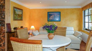 A cozy living room with a round table, wicker chairs, a white sofa, and two framed pictures on the walls. - Gorgeous home in Tharandt with WiFi (Tharandt)