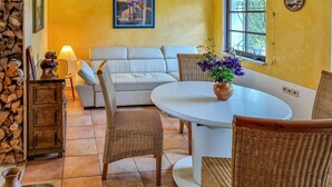 A cozy living room with a white sofa, wicker chairs, a round table, and a potted plant. - Gorgeous home in Tharandt with WiFi (Tharandt)