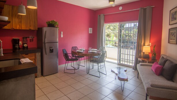 Un espacio habitable compacto con cocina, comedor y sofá.