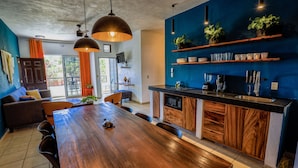 Una cocina moderna con una mesa de comedor de madera, electrodomésticos integrados y paredes de acento azul.