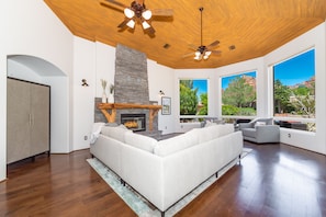 Relax by the stone fireplace in this inviting living space with high ceilings and expansive views.
