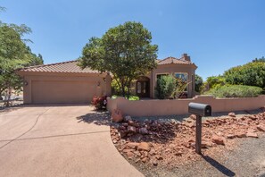A single-story house with a garage, a small porch, and a mailbox.