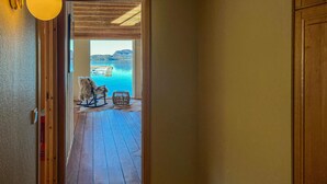 Un intérieur en bois qui donne sur un balcon offrant une vue sur un lac et un quai.