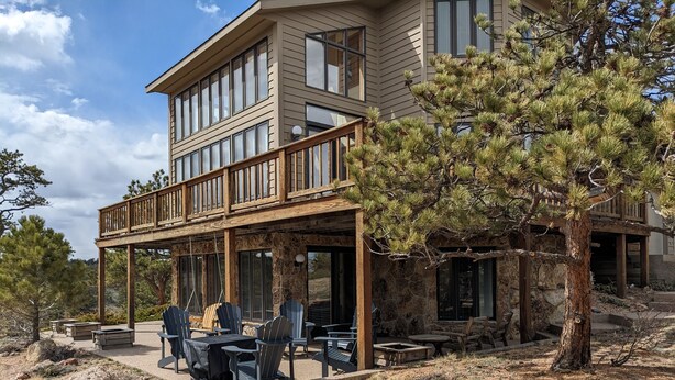 A two-story house with a covered patio area featuring outdoor seating and a stone facade. - Vedauwoo, Curt Gowdy State Park, Cheyenne, and Laramie  close! (Cheyenne)