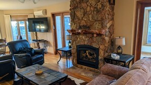 A cozy living room with a stone fireplace, leather sofas, and a flat-screen TV. - Vedauwoo, Curt Gowdy State Park, Cheyenne, and Laramie  close! (Cheyenne)