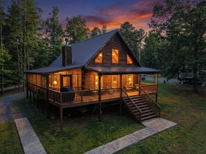A wooden cabin with a porch, a chimney, and a deck. - Cozy Cabin With Dock, Huge Screen-In Porch, Fire Pit, Fast WiFi and Pet Friendly (Decatur)