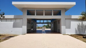 Un bâtiment moderne avec une entrée centrale, de nombreuses fenêtres et un ciel dégagé.
