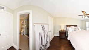A bedroom with a bed, dresser, nightstand, and a ceiling fan. - CITY CONDO (Houston)