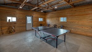 A ping pong table in a room with wooden walls and a high ceiling.