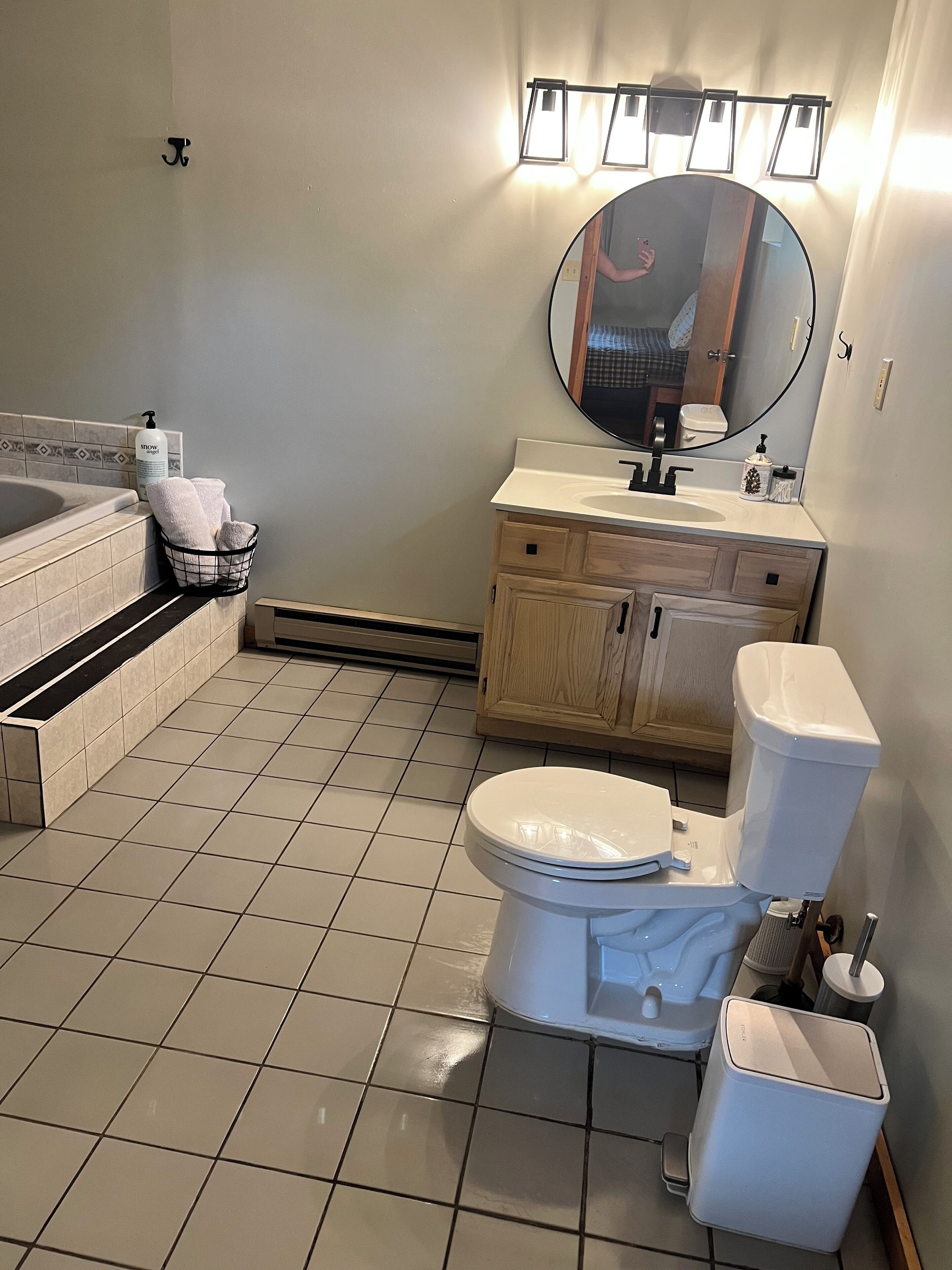Un baño con bañera, inodoro, lavabo y espejo.