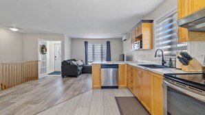 A modern kitchen with wooden cabinets, a dishwasher, and a stove. - *WOW!!* Executive cozy home with 3 beds, work station & gym (St. John's)