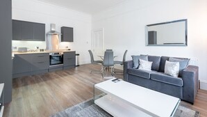 Een modern appartement met een keuken, een eethoek en een woonkamer.