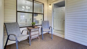 A porch with two chairs, a small table, and a potted plant. - Newly Remodeled Townhome(RD) (North Charleston)
