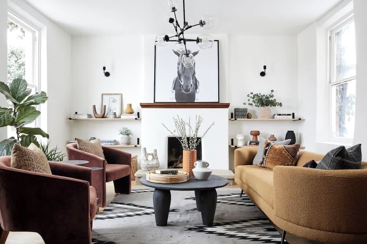 A modern living room with a fireplace, two sofas, and a coffee table.