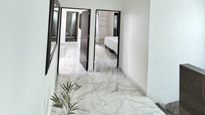 A hallway with a marble floor leading to a bedroom with a bed and a bathroom. - Magnífica casa con piscina privada a 10 min del mar (Cancún)