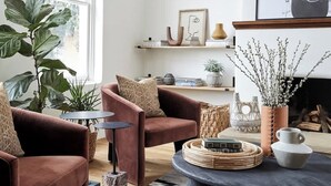 Una sala de estar moderna con un ventanal grande, una chimenea y un candelabro.