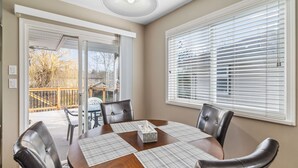 A dining area with a round table, four chairs, and a tissue box. - Beautiful Home in Langley with Huge Patio (Langley)