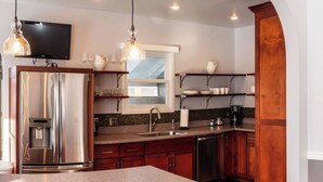 Una cocina moderna con una isla central, electrodomésticos de acero inoxidable y armarios de madera.