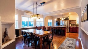 Una cocina amplia con suelo de madera, una zona de comedor con una mesa grande y sillas, y una isla de cocina.