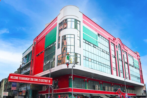 Un edificio de varios pisos con fachada roja y blanca, ventanas amplias y un letrero que indica que se encuentra en el Barangay 268 Zona 25 Distrito III.
