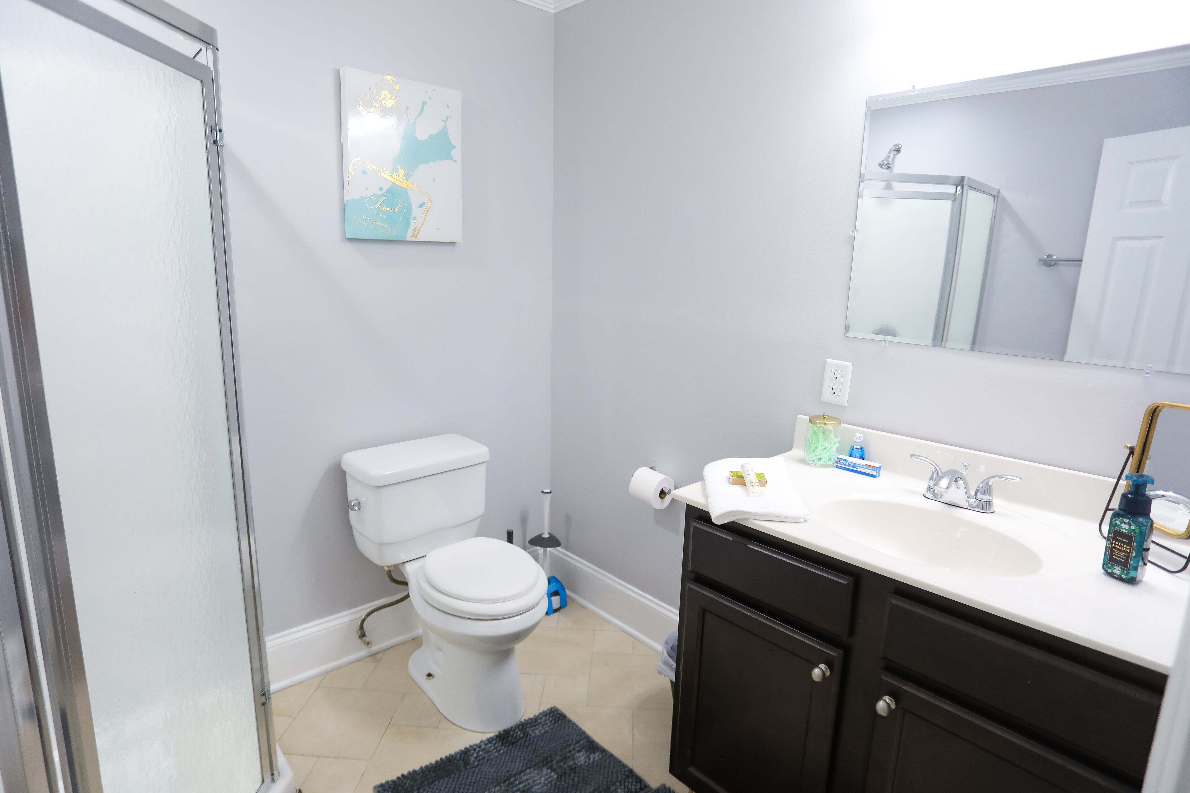 A bathroom with a toilet, sink, and mirror.
