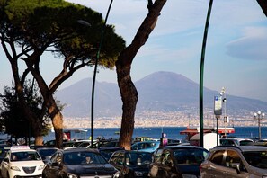A parking lot with cars and a view of a cityscape and a mountain in the background. - First House Posillipo Holiday Home Naples (Naples)