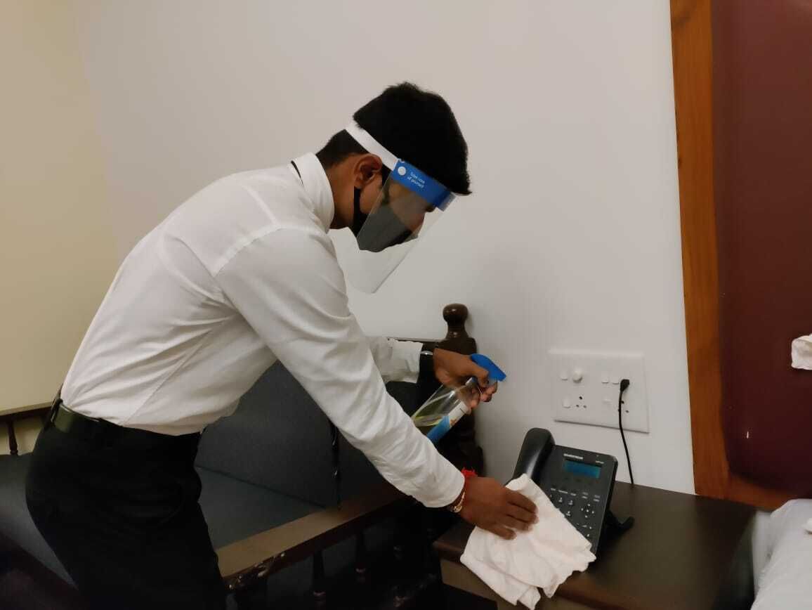A person cleaning a desk in an office setting.
