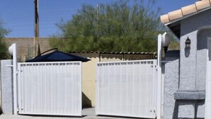 A gated entrance with a concrete driveway and a yellow line marking. - Beautiful suited with separate entrance (Las Vegas)
